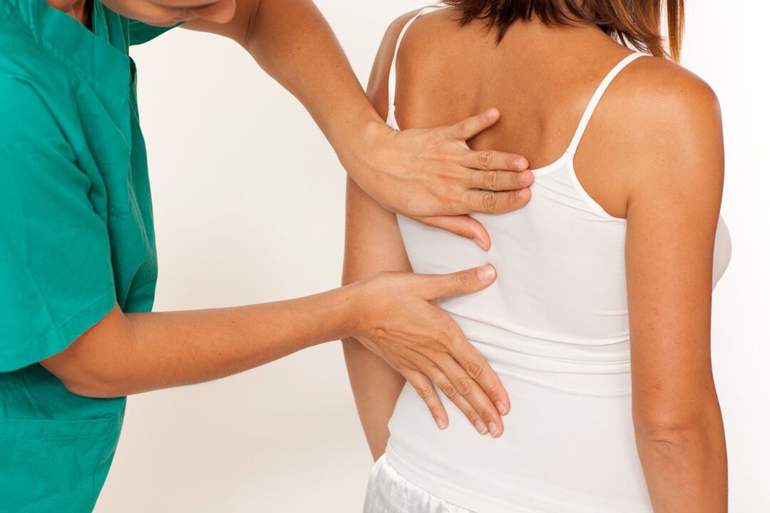 el médico examina la espalda en busca de dolor en el área de los omóplatos